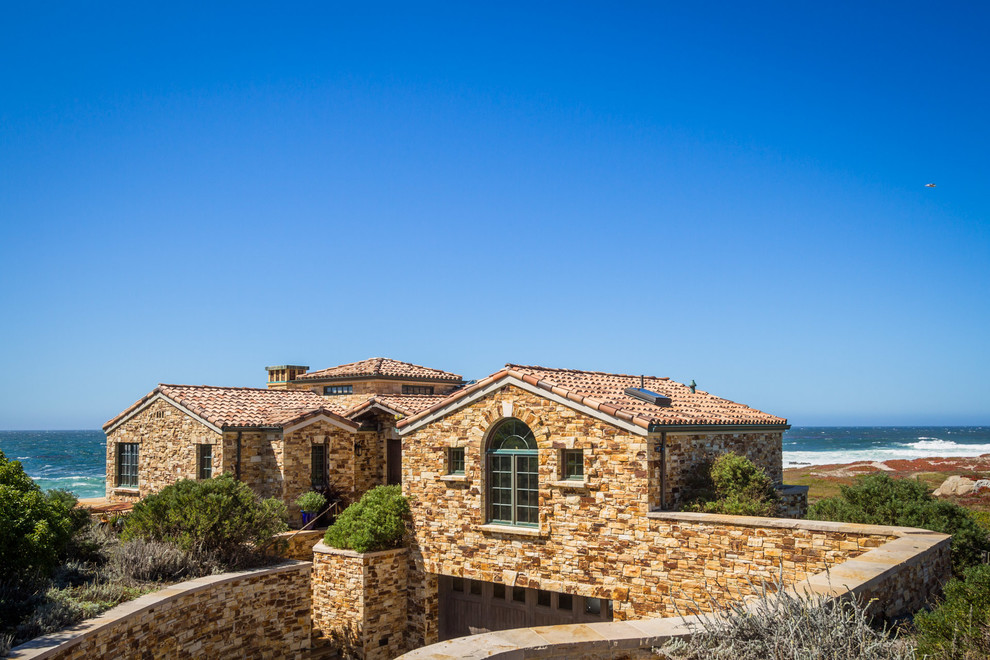 Mediterranean one-story stone exterior home idea in Other