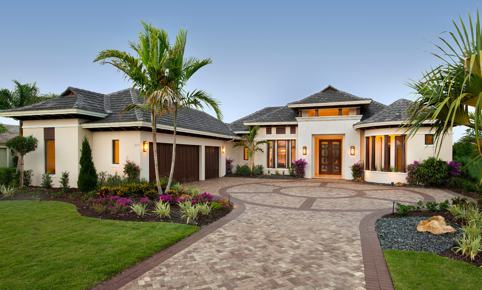 Ispirazione per la facciata di una casa beige tropicale a un piano con tetto a padiglione