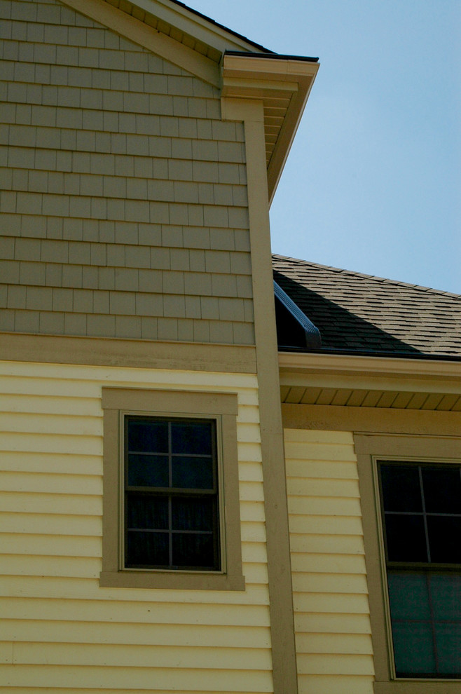 Idées déco pour une façade de maison beige classique en panneau de béton fibré de taille moyenne et à deux étages et plus avec un toit à deux pans et un toit en shingle.