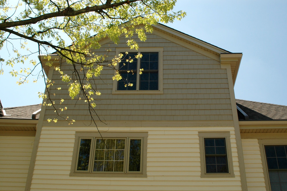 Inspiration pour une façade de maison beige traditionnelle en panneau de béton fibré de taille moyenne et à deux étages et plus avec un toit à deux pans et un toit en shingle.