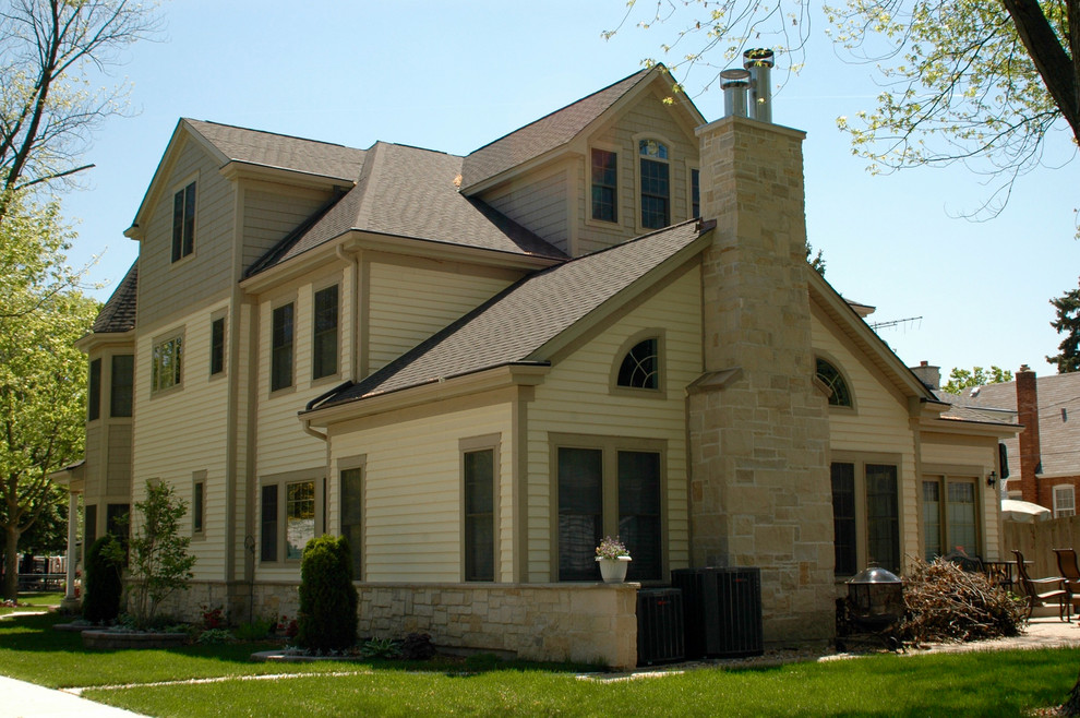Immagine della villa beige classica a tre piani di medie dimensioni con rivestimento con lastre in cemento, tetto a capanna e copertura a scandole