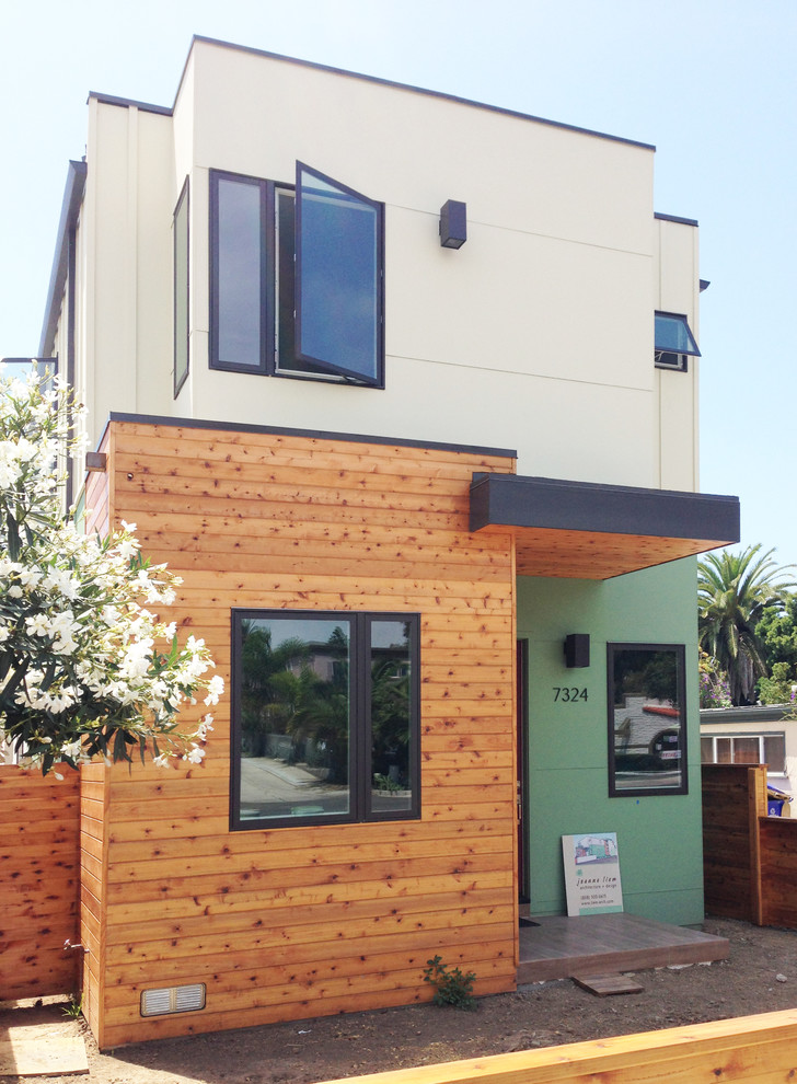 Aménagement d'une façade de maison verte contemporaine de taille moyenne et à niveaux décalés avec un revêtement mixte.