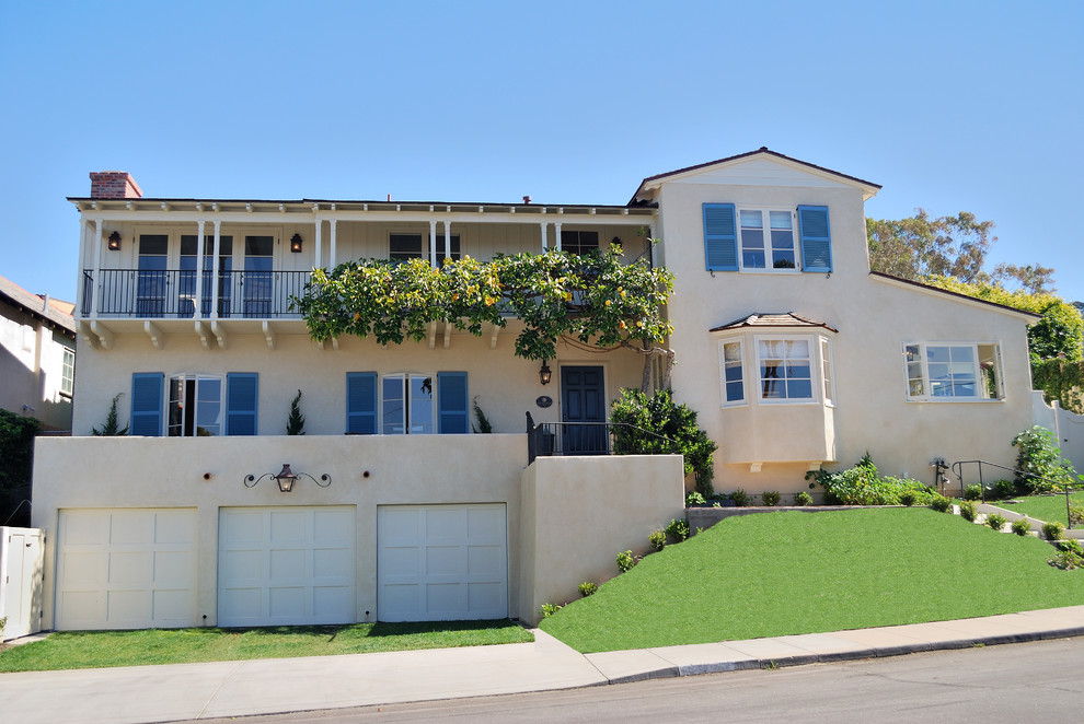 This is an example of a yellow traditional render house exterior in San Diego with three floors.