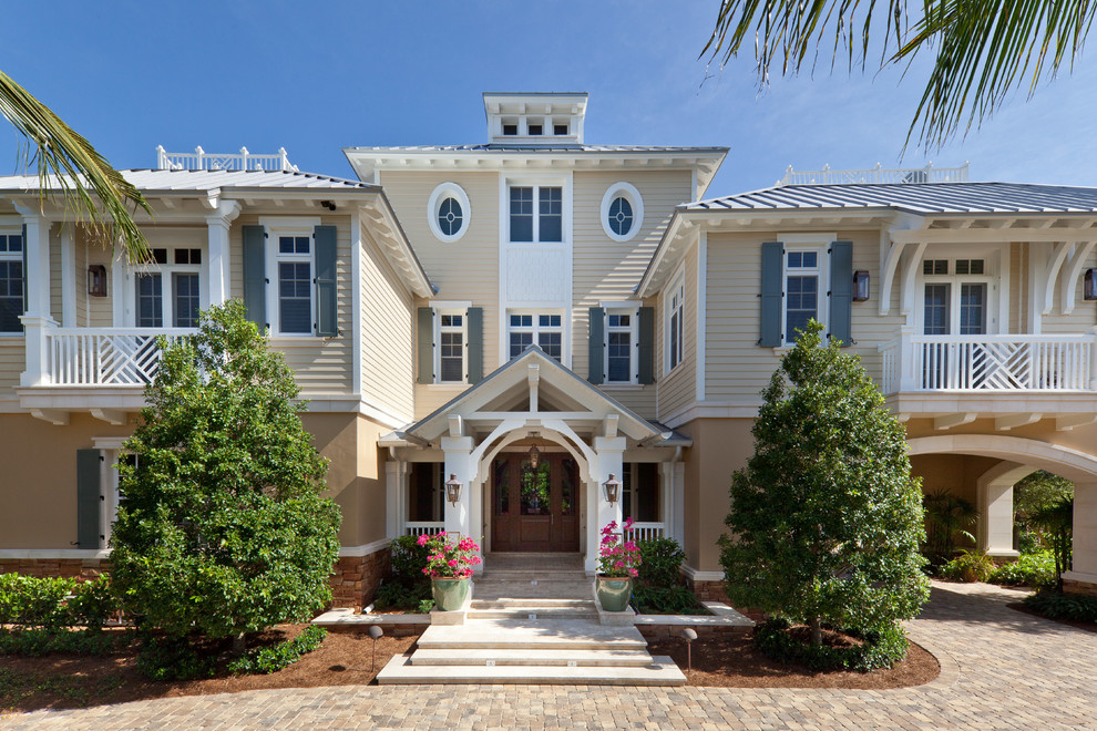 This is an example of a beige world-inspired two floor house exterior in Miami.