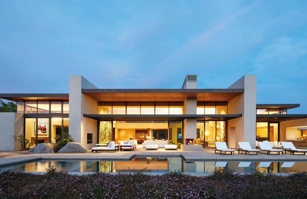 Idee per la villa grande beige moderna a un piano con rivestimento in stucco, tetto piano e copertura in tegole
