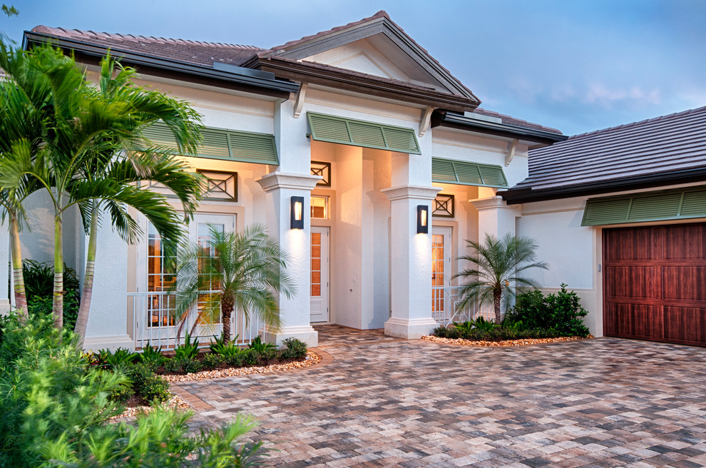 Einstöckiges Haus mit Putzfassade, weißer Fassadenfarbe und Walmdach in Miami