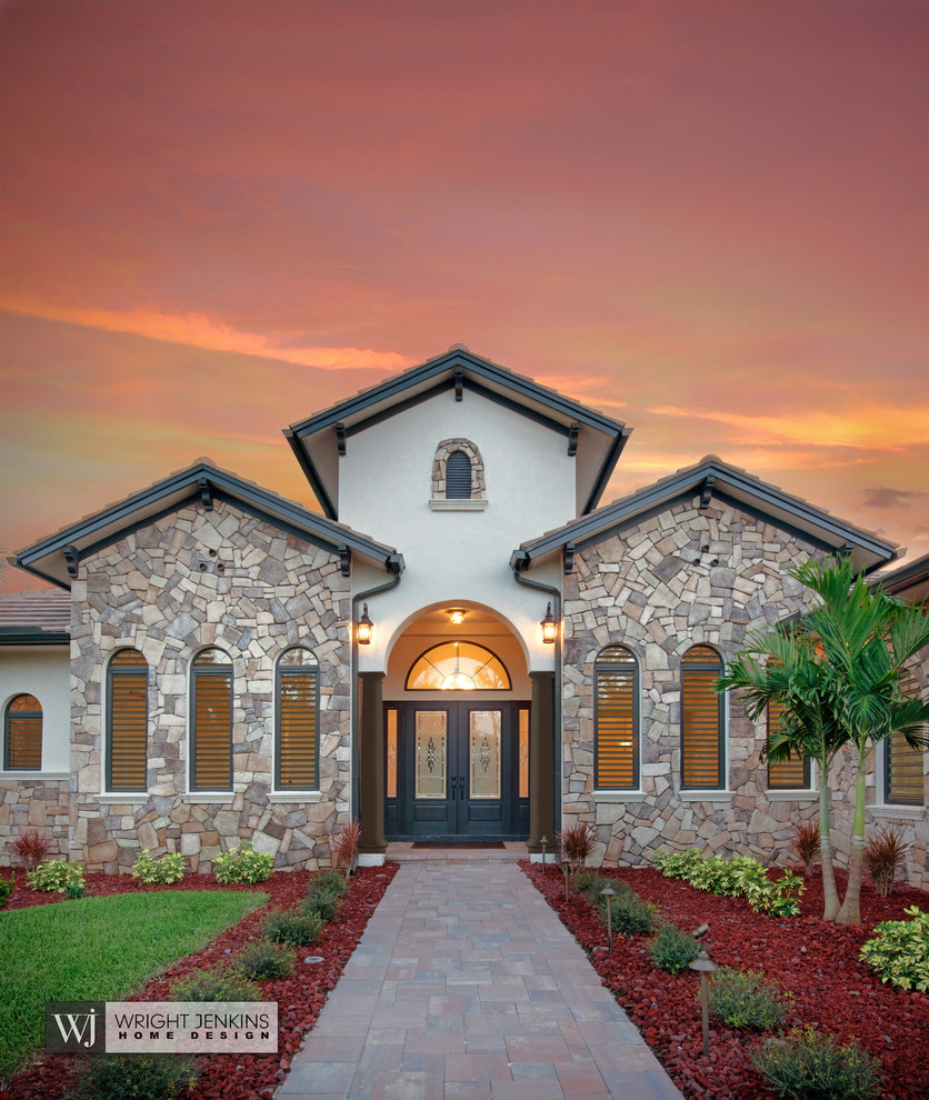 Mid-sized tuscan beige one-story mixed siding house exterior photo in Other with a hip roof and a tile roof