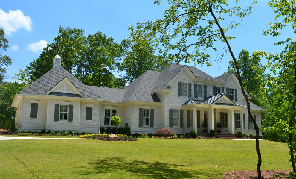 Imagen de fachada de casa blanca de estilo de casa de campo de tamaño medio de dos plantas con revestimientos combinados, tejado de varios materiales y tejado a cuatro aguas