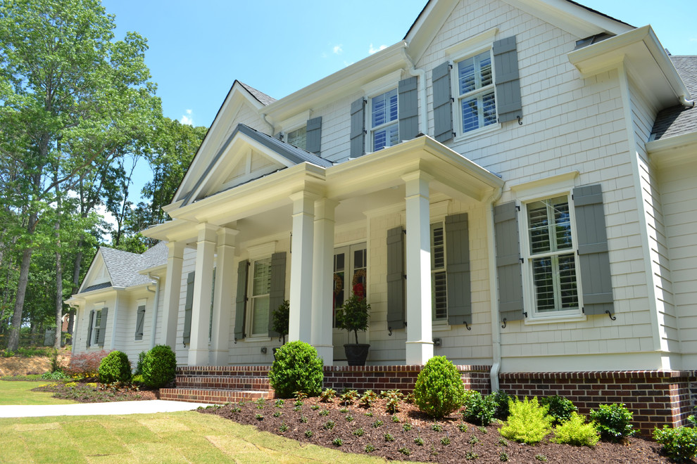 Ejemplo de fachada de casa blanca de estilo de casa de campo de tamaño medio de dos plantas con revestimientos combinados