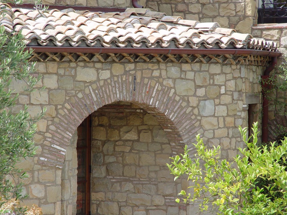 Modelo de fachada beige mediterránea de tamaño medio de dos plantas con revestimiento de piedra y tejado plano