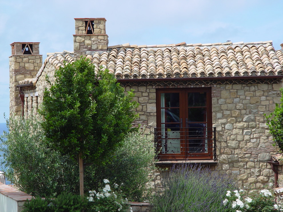 Источник вдохновения для домашнего уюта: двухэтажный, бежевый дом среднего размера в средиземноморском стиле с облицовкой из камня и плоской крышей