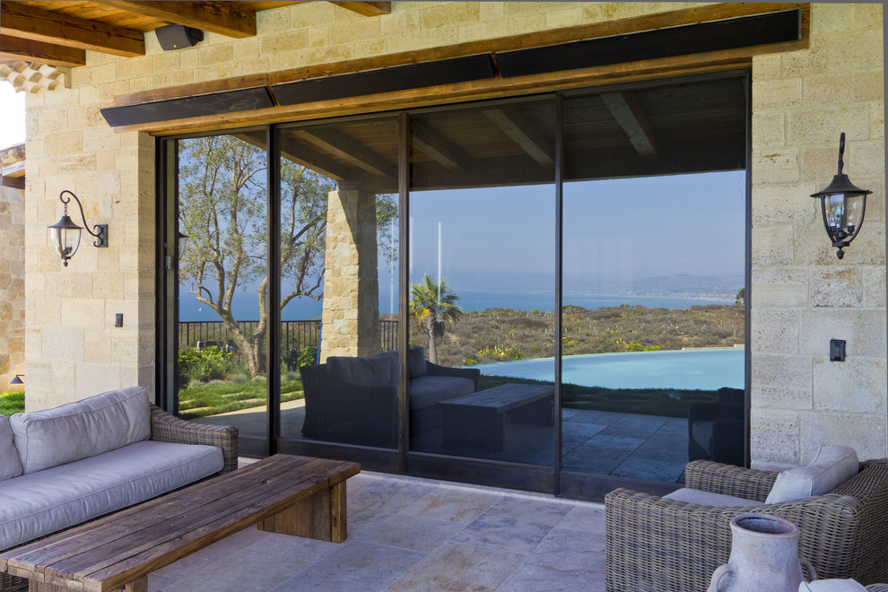 Inspiration for a large mediterranean gray three-story stone exterior home remodel in Santa Barbara