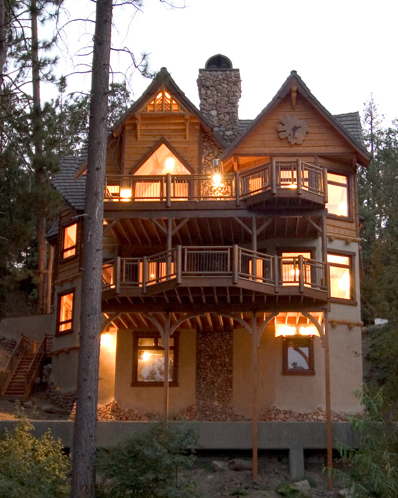 Cette image montre une grande façade de maison marron chalet à deux étages et plus avec un revêtement mixte, un toit à deux pans et un toit en shingle.