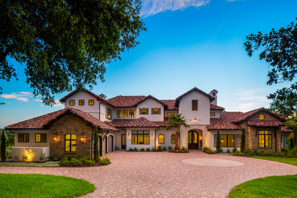 Inspiration for a large and white mediterranean two floor detached house in Austin with stone cladding, a pitched roof and a tiled roof.