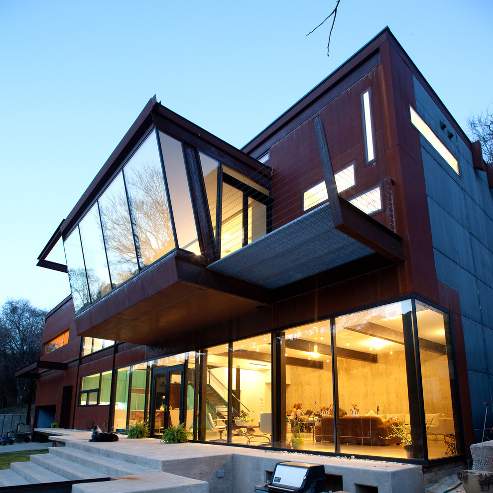 Idee per la facciata di una casa moderna a due piani con rivestimenti misti e terreno in pendenza