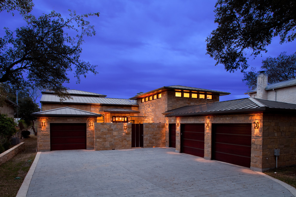 Large contemporary beige two-story stone exterior home idea in Austin with a hip roof