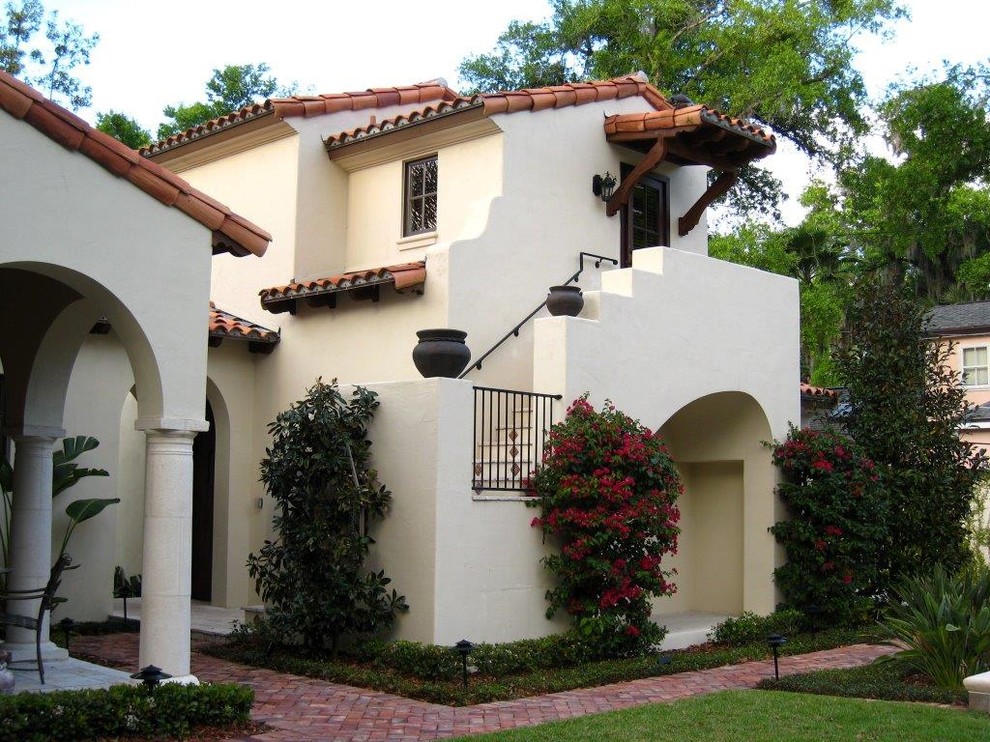 Inspiration for a large mediterranean white two-story stucco exterior home remodel in Orlando with a hip roof