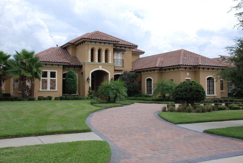 Example of a mid-sized tuscan brown two-story stucco gable roof design in Orlando