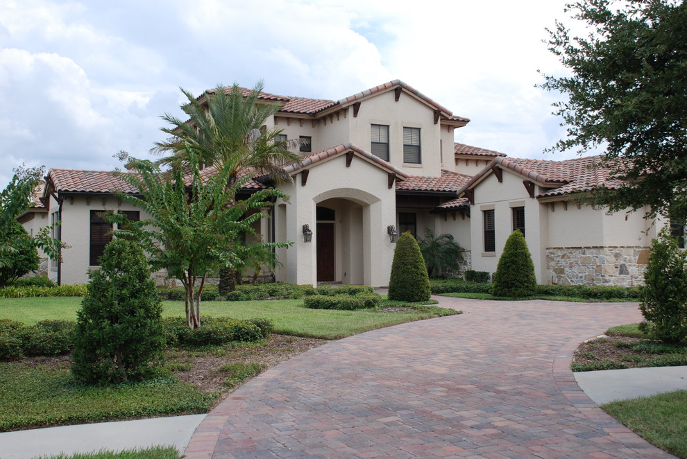 Inspiration for a large mediterranean beige two-story mixed siding gable roof remodel in Orlando