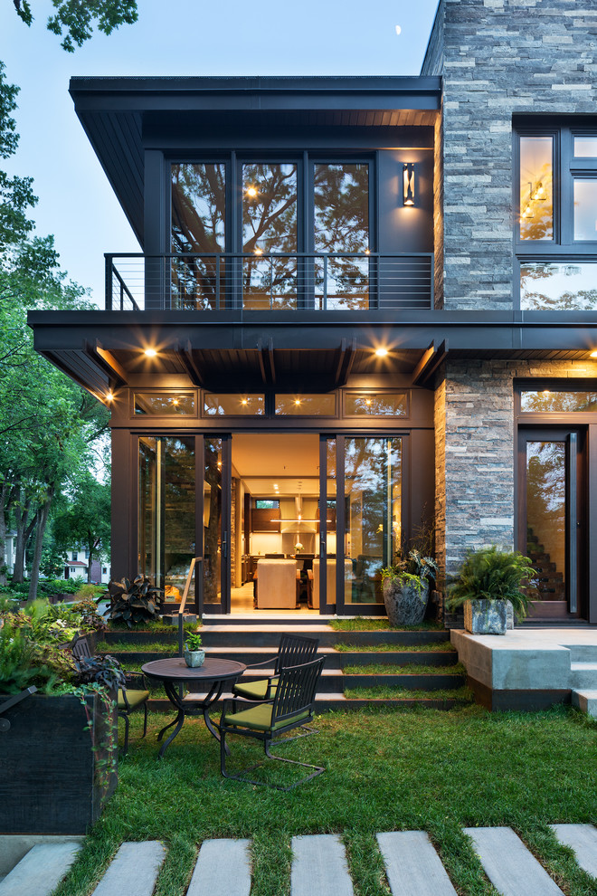 На фото: маленький, двухэтажный, серый дом в стиле модернизм с комбинированной облицовкой и плоской крышей для на участке и в саду с