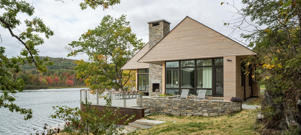Réalisation d'une grande façade de maison beige design à un étage avec un toit à deux pans, un revêtement mixte et un toit en métal.