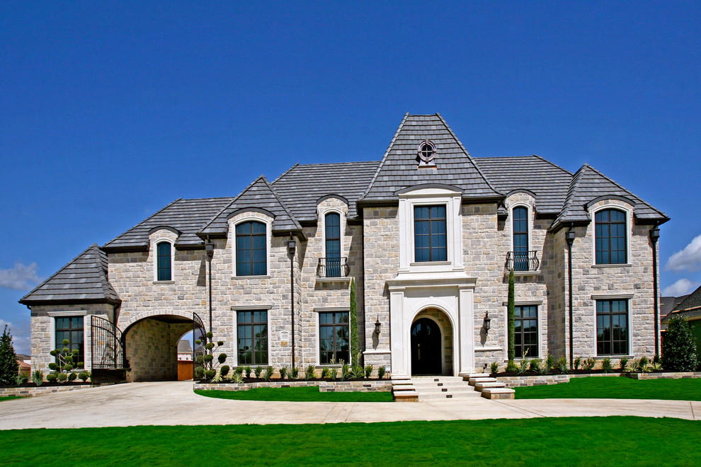Large transitional beige two-story stone exterior home idea in Dallas