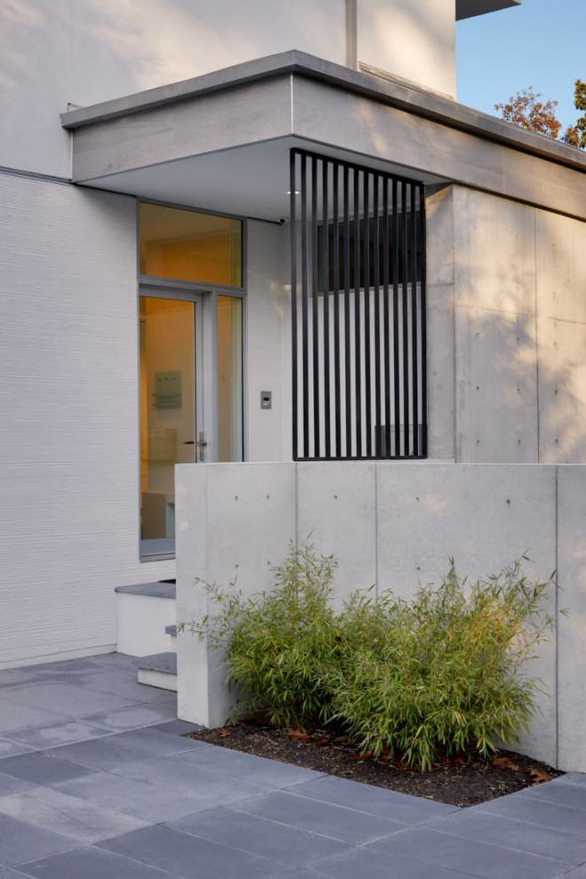 Large minimalist white three-story concrete exterior home photo in New York