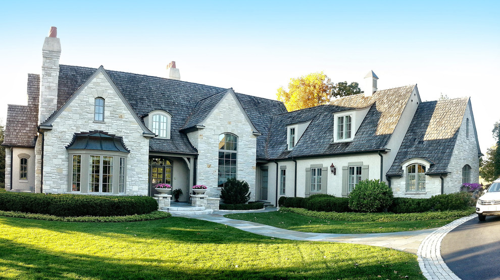 This is an example of a beige classic two floor house exterior in Chicago with stone cladding.