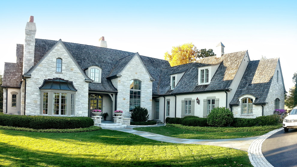 Elegant beige two-story stone exterior home photo in Chicago