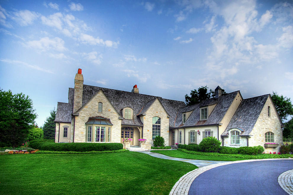 Elegant beige two-story stone exterior home photo in Chicago