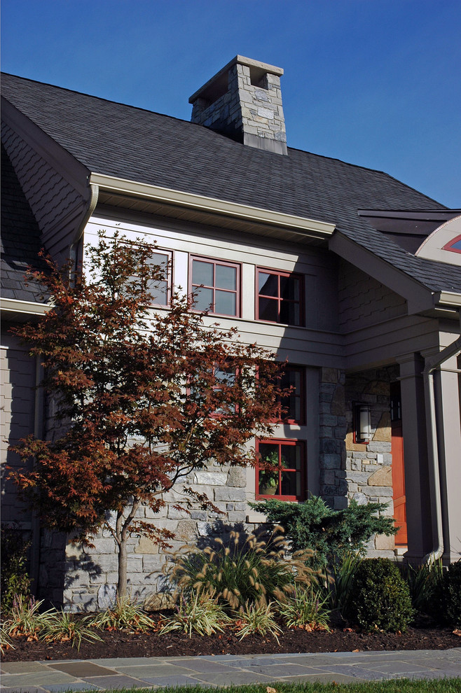 Esempio della facciata di una casa grande beige american style a due piani con rivestimento in pietra