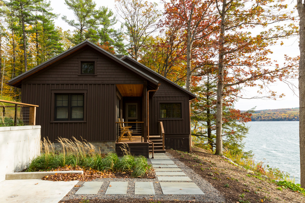 Стильный дизайн: двухэтажный, деревянный, коричневый дом среднего размера в стиле рустика с двускатной крышей - последний тренд