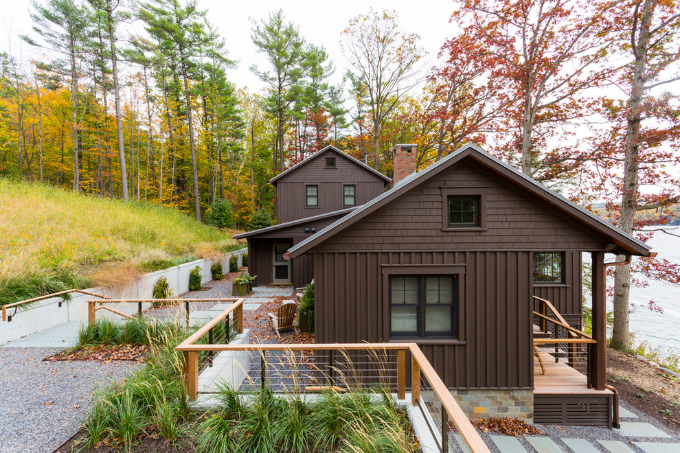 Modelo de fachada de casa marrón rústica de tamaño medio de dos plantas con revestimiento de madera y tejado a dos aguas