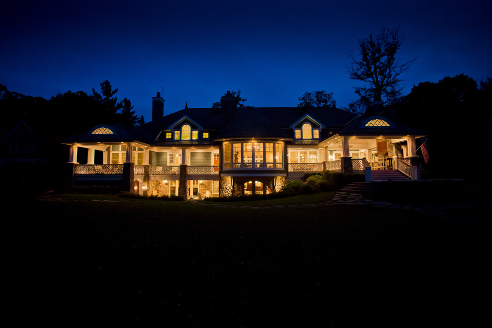 Стильный дизайн: большой, двухэтажный, синий дом в классическом стиле с облицовкой из винила и полувальмовой крышей - последний тренд