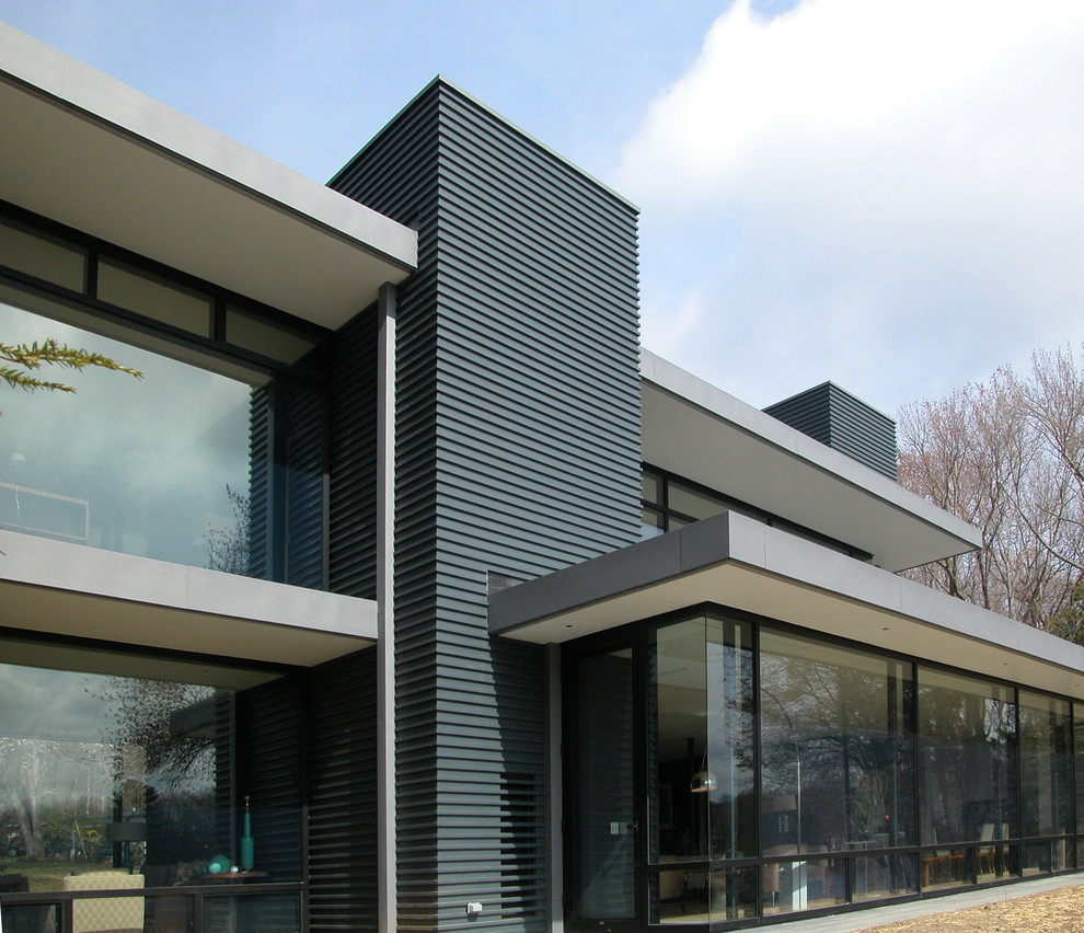Imagen de fachada de casa gris minimalista grande de dos plantas con revestimiento de hormigón y tejado plano