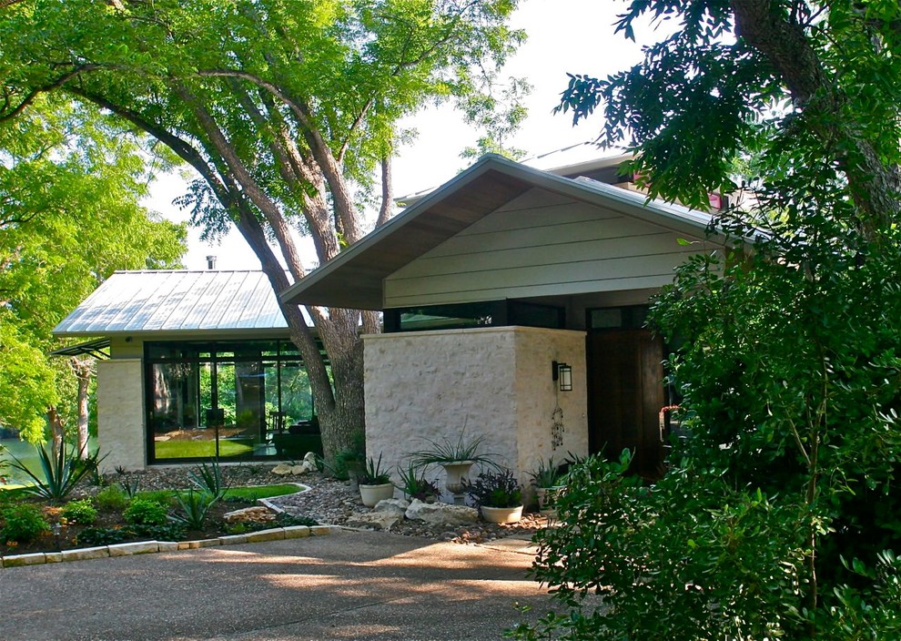 На фото: одноэтажный, серый частный загородный дом среднего размера в стиле модернизм с комбинированной облицовкой, двускатной крышей и металлической крышей