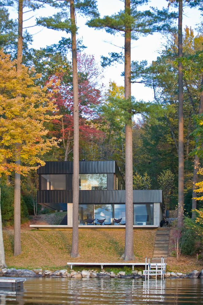 Aménagement d'une façade de maison moderne à un étage avec un toit plat et un revêtement mixte.