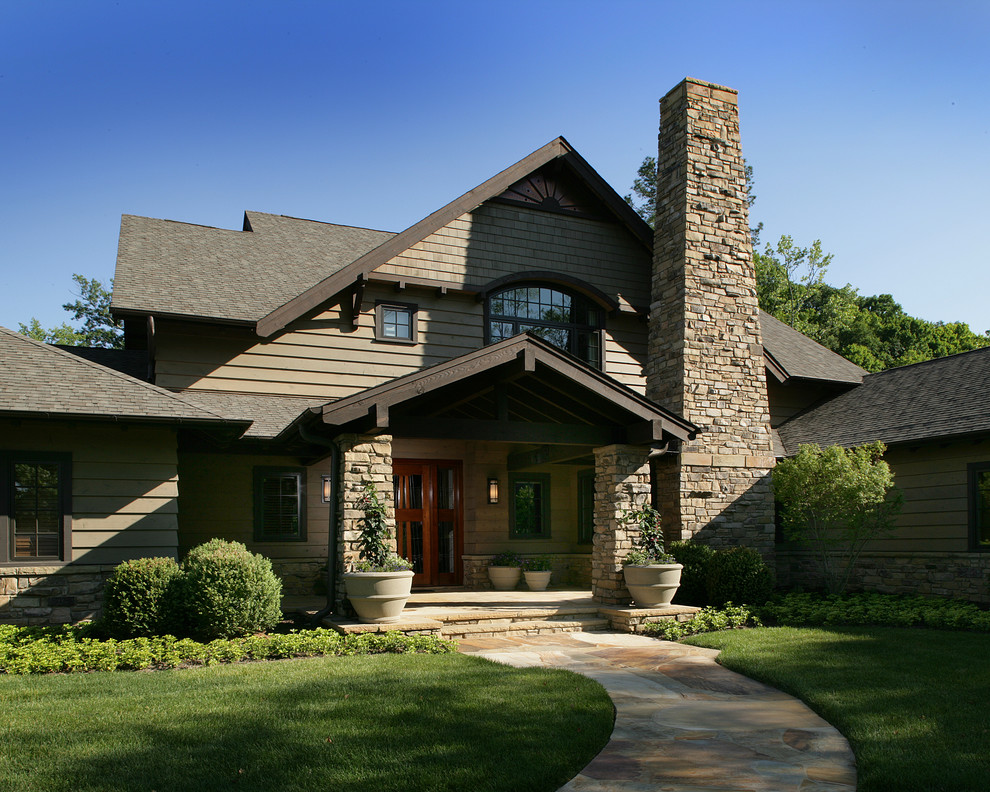 Esempio della facciata di una casa grande verde classica a due piani con rivestimento in legno e tetto a padiglione