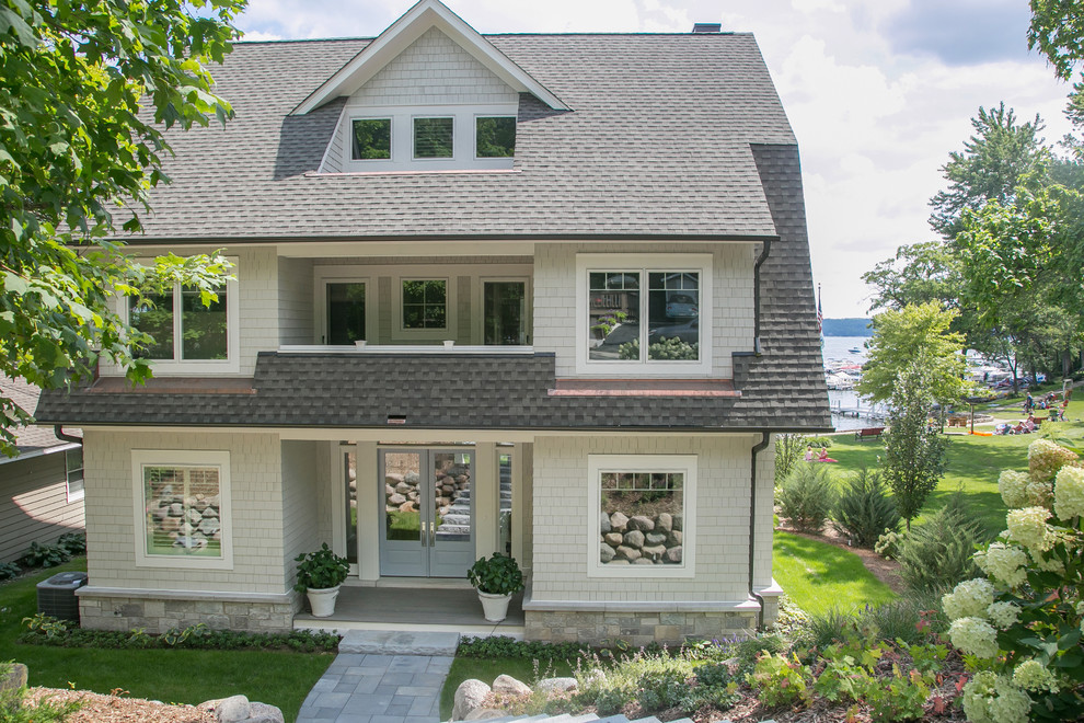 Inspiration for a large transitional gray two-story wood house exterior remodel in Milwaukee with a shingle roof