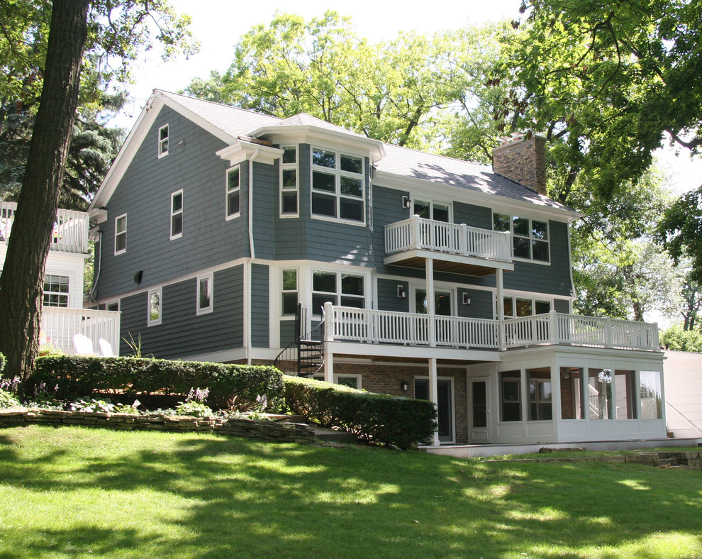 Foto della facciata di una casa blu classica a tre piani di medie dimensioni con rivestimento in mattoni e tetto piano