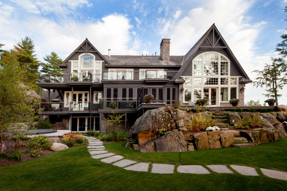 Inspiration pour une façade de maison grise chalet en bois à un étage avec un toit à deux pans et un toit en shingle.