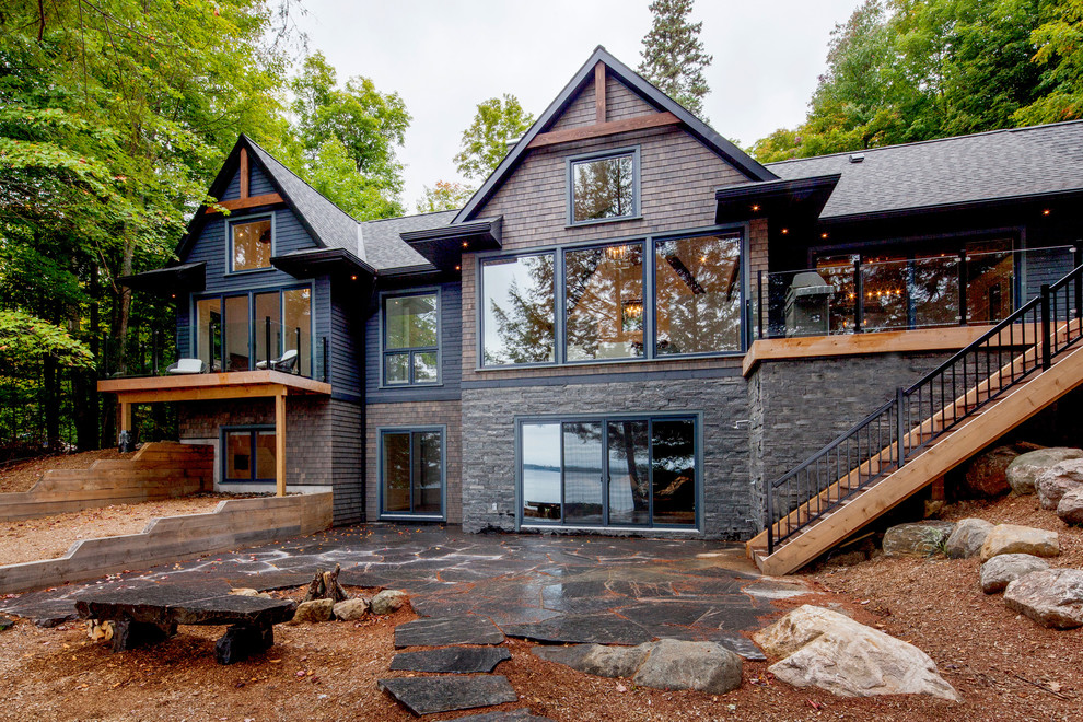 Свежая идея для дизайна: серый дом среднего размера в классическом стиле с разными уровнями, облицовкой из камня и двускатной крышей - отличное фото интерьера