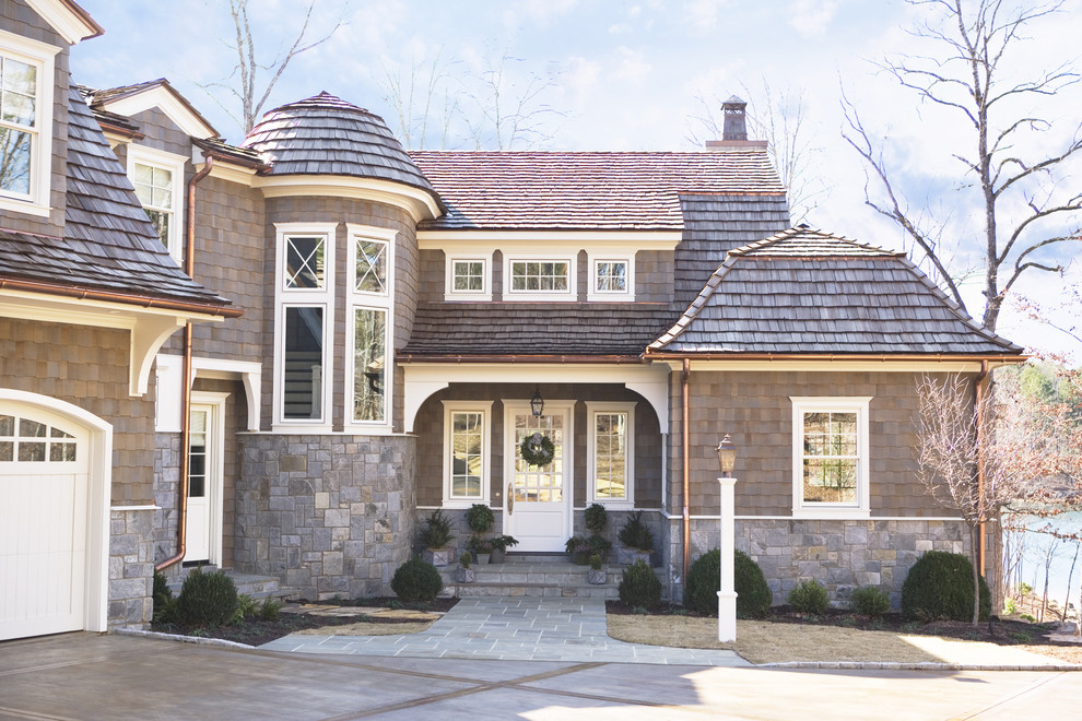 Idee per la facciata di una casa grande marrone classica a due piani con rivestimento in pietra e copertura a scandole