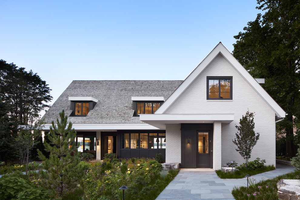 Foto de fachada de casa blanca tradicional renovada de dos plantas con revestimiento de ladrillo, tejado a dos aguas y tejado de teja de madera