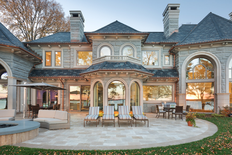 Ispirazione per la facciata di una casa ampia grigia classica a due piani con rivestimento in pietra e tetto a padiglione