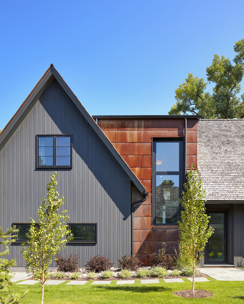 Inspiration pour une façade de maison multicolore chalet à un étage avec un revêtement mixte, un toit à deux pans et un toit en shingle.
