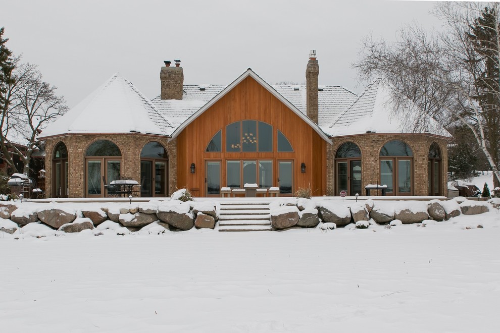 Example of a classic brown one-story mixed siding house exterior design in Minneapolis with a hip roof and a shingle roof