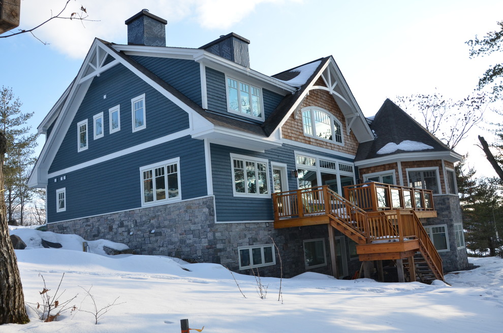 Idée de décoration pour une grande façade de maison bleue design en bois à un étage avec un toit à deux pans.