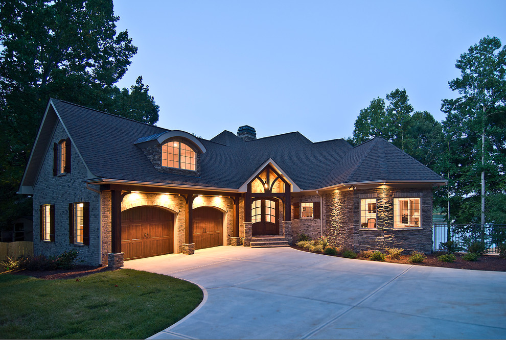 Exemple d'une façade de maison beige chic en pierre de taille moyenne et de plain-pied avec un toit à quatre pans.