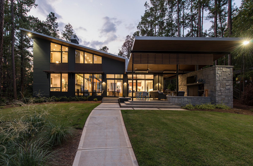 Стильный дизайн: двухэтажный, серый частный загородный дом среднего размера в современном стиле с комбинированной облицовкой и односкатной крышей - последний тренд